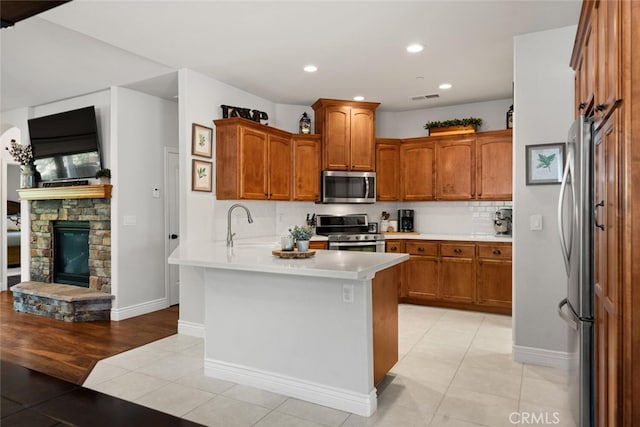 kitchen featuring a peninsula, stainless steel appliances, tasteful backsplash, visible vents, and light tile patterned floors