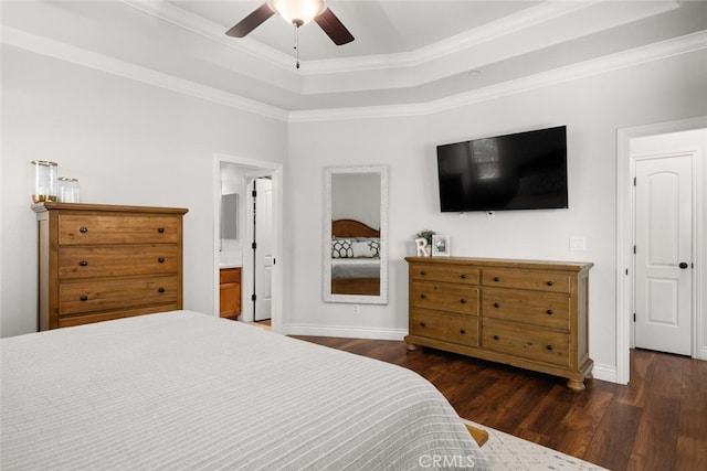 bedroom with a tray ceiling, dark wood-type flooring, baseboards, and ornamental molding