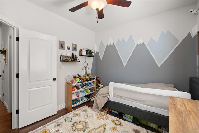 bedroom with baseboards, wood finished floors, and a ceiling fan