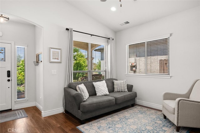 living area featuring a wealth of natural light, baseboards, visible vents, and wood finished floors