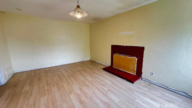 unfurnished living room featuring wood finished floors and baseboards