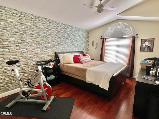 bedroom with a ceiling fan, wood finished floors, and vaulted ceiling