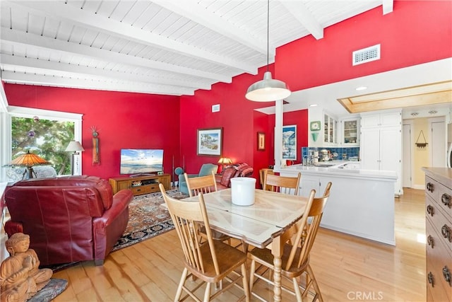 2245 Avenida Salvador, San Clemente, CA 92672 - dining area with light wood-style flooring, an accent wall, and a wood ceiling with exposed beams