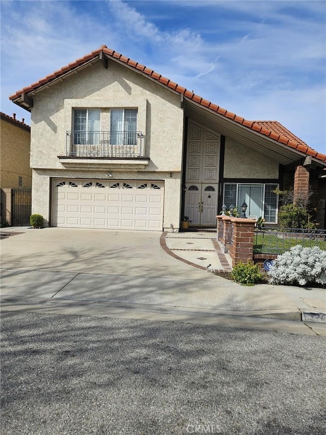 mediterranean / spanish-style house with stucco siding, concrete driveway, a garage, and a tiled roof
