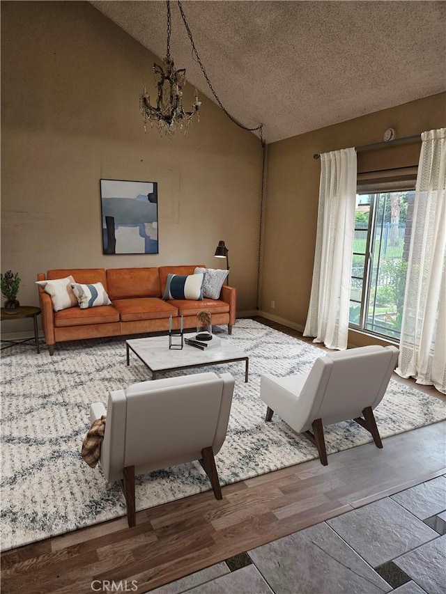living area featuring lofted ceiling, a chandelier, a textured ceiling, and wood finished floors