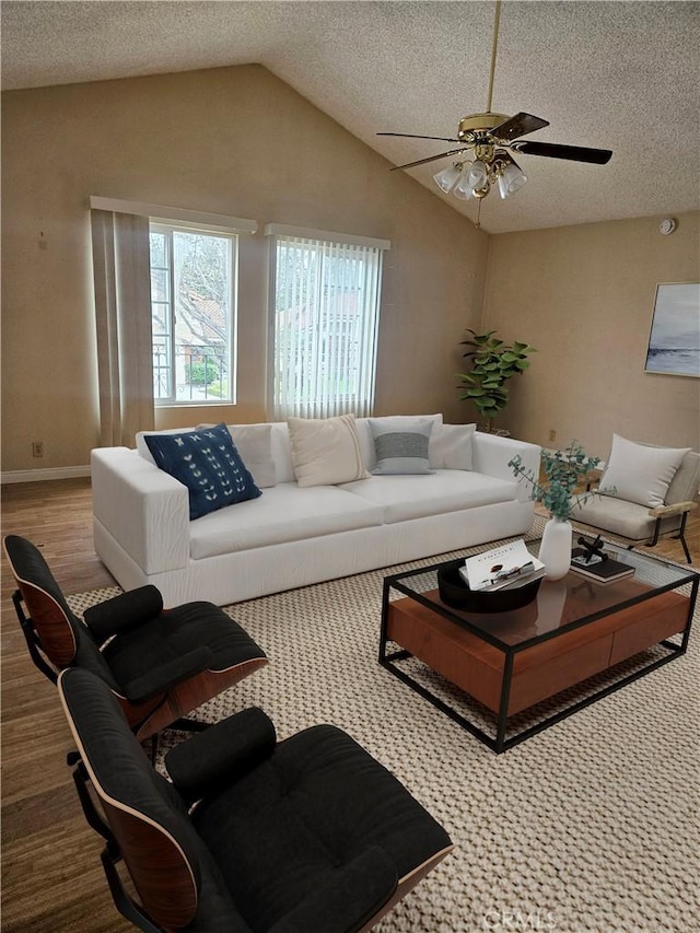 living room featuring lofted ceiling, baseboards, ceiling fan, and a textured ceiling