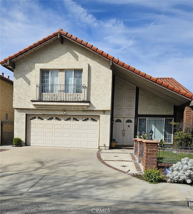 mediterranean / spanish-style house featuring a garage, stucco siding, and driveway