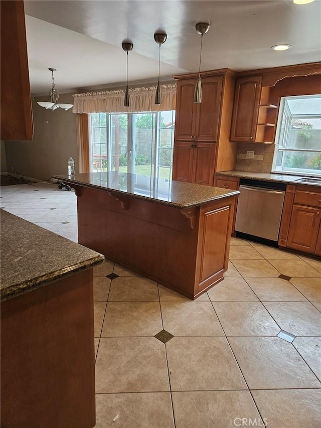 kitchen featuring dishwasher, plenty of natural light, tasteful backsplash, and a kitchen breakfast bar