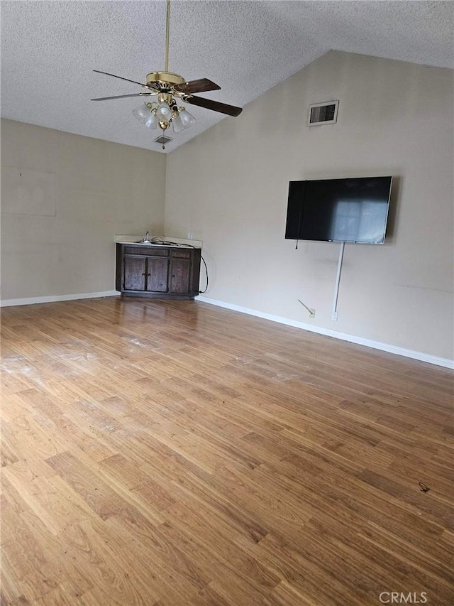 unfurnished living room featuring a textured ceiling and wood finished floors
