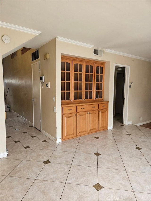 hall with ornamental molding, baseboards, light tile patterned floors, and visible vents