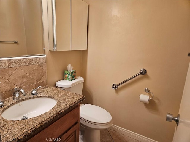 half bath featuring tile patterned floors, toilet, baseboards, and vanity