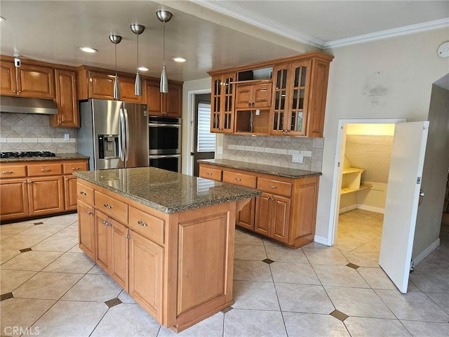 kitchen featuring under cabinet range hood, crown molding, stainless steel appliances, and brown cabinetry