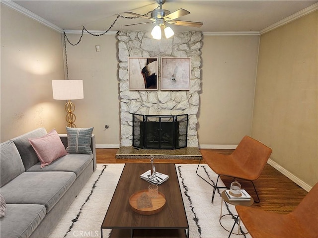 living area with ornamental molding, wood finished floors, baseboards, and ceiling fan