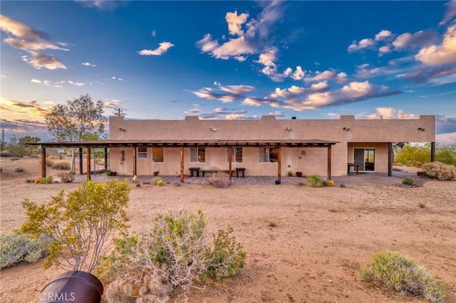 rear view of house with a patio and stucco siding