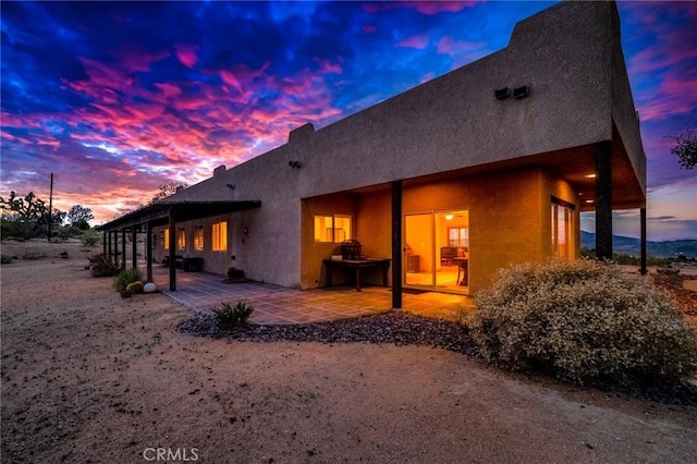 rear view of property featuring a patio area and stucco siding