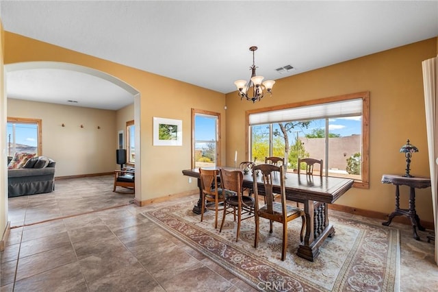 dining room with arched walkways, baseboards, an inviting chandelier, and visible vents