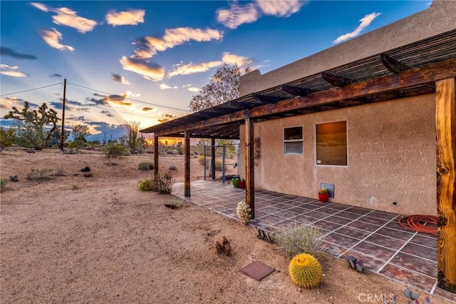 61465 Latham Trl, Joshua Tree, CA 92252 - view of property exterior featuring a pergola, a patio, and stucco siding