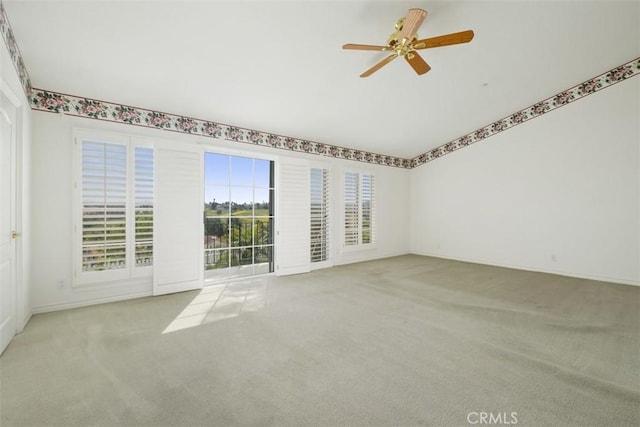 carpeted empty room featuring ceiling fan and baseboards