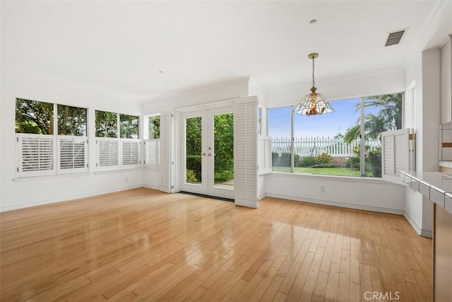 unfurnished sunroom with french doors and a chandelier