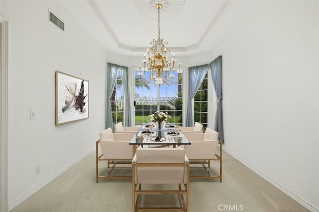 dining space with a chandelier, a tray ceiling, baseboards, carpet, and ornamental molding