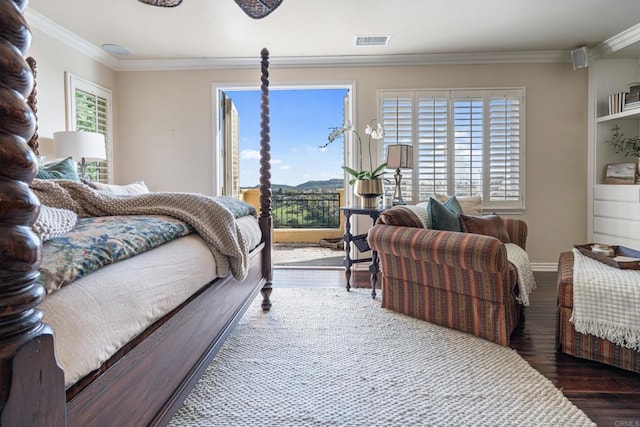bedroom featuring a mountain view, wood finished floors, visible vents, baseboards, and ornamental molding