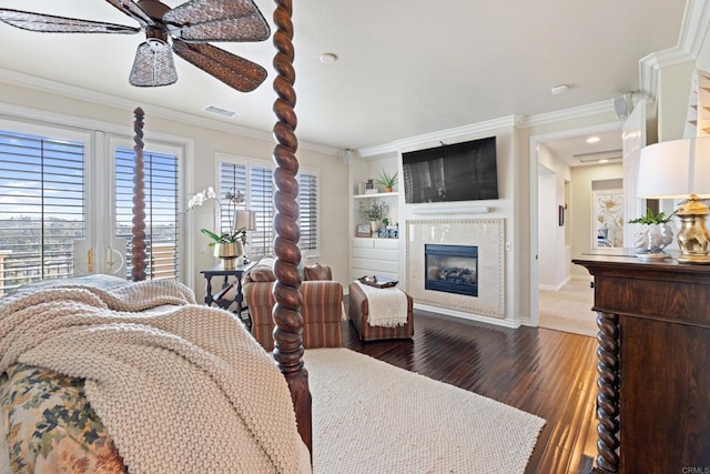 bedroom featuring baseboards, multiple windows, a glass covered fireplace, and dark wood-type flooring