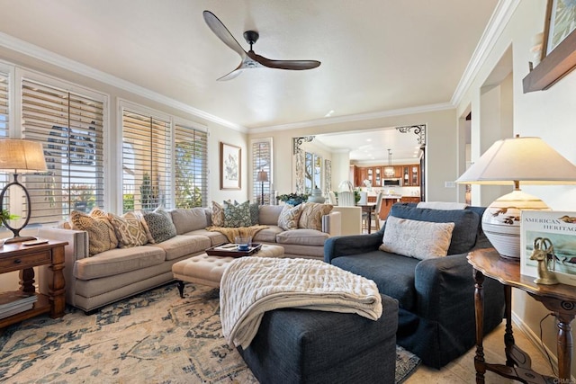 living room with ornamental molding and ceiling fan with notable chandelier