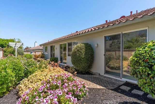 2331 Humboldt St, Los Osos, CA 93402 - view of side of home featuring stucco siding, a tile roof, and a patio area