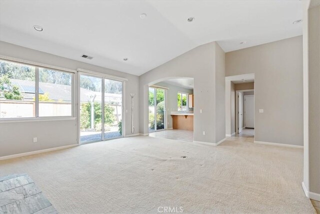 2331 Humboldt St, Los Osos, CA 93402 - unfurnished living room featuring vaulted ceiling, light colored carpet, arched walkways, baseboards, and recessed lighting