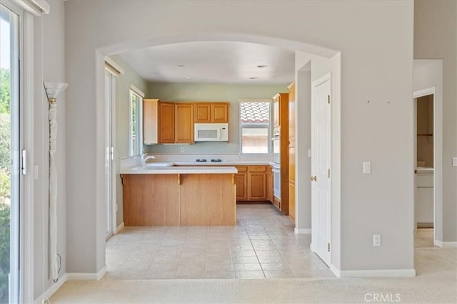 2331 Humboldt St, Los Osos, CA 93402 - kitchen with white microwave, arched walkways, light countertops, a peninsula, and baseboards