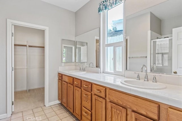 2331 Humboldt St, Los Osos, CA 93402 - bathroom featuring a shower stall, double vanity, tile patterned flooring, and baseboards