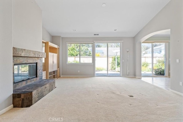 2331 Humboldt St, Los Osos, CA 93402 - unfurnished living room with baseboards, carpet, a fireplace, vaulted ceiling, and arched walkways
