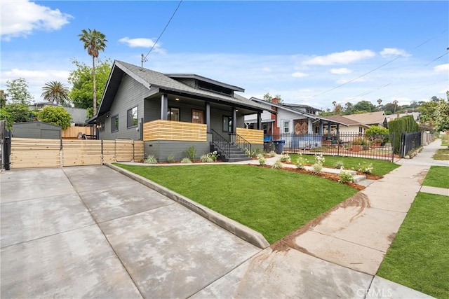 bungalow with a porch, a front lawn, fence, and a gate