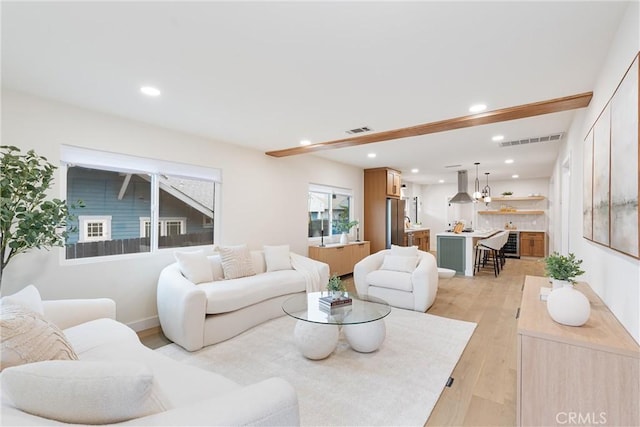 living room with light wood finished floors, visible vents, and recessed lighting