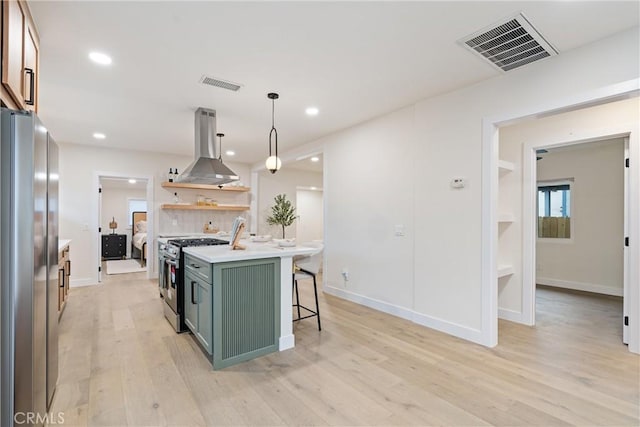 6123 Tipton Way, Los Angeles, CA 90042 - kitchen featuring appliances with stainless steel finishes, island exhaust hood, green cabinets, a kitchen bar, and light countertops