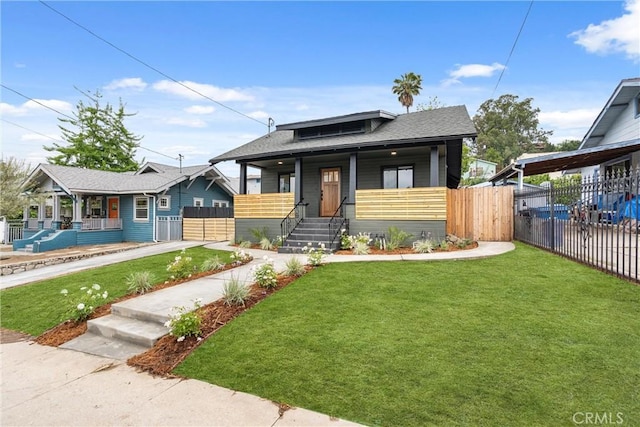 bungalow-style home with a front lawn, a porch, roof with shingles, and fence