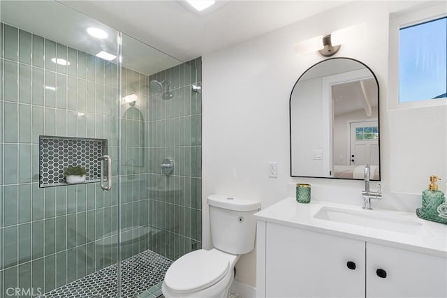 bathroom with a shower stall, vanity, and toilet