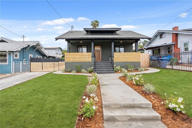 bungalow with a porch, fence, and a front yard