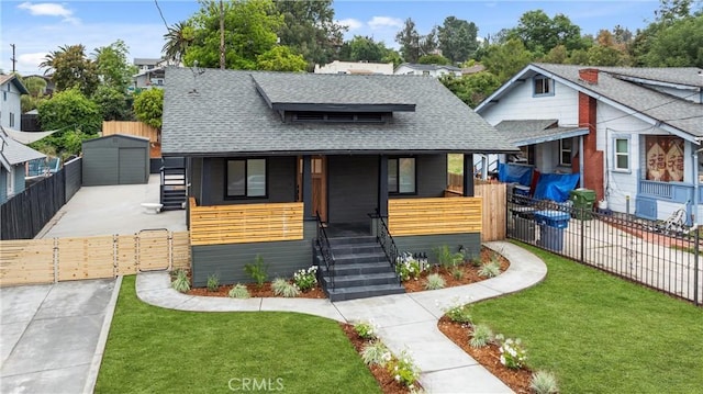 bungalow-style home with covered porch, roof with shingles, and a front yard