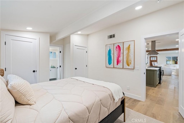 bedroom with baseboards, light wood finished floors, recessed lighting, and visible vents