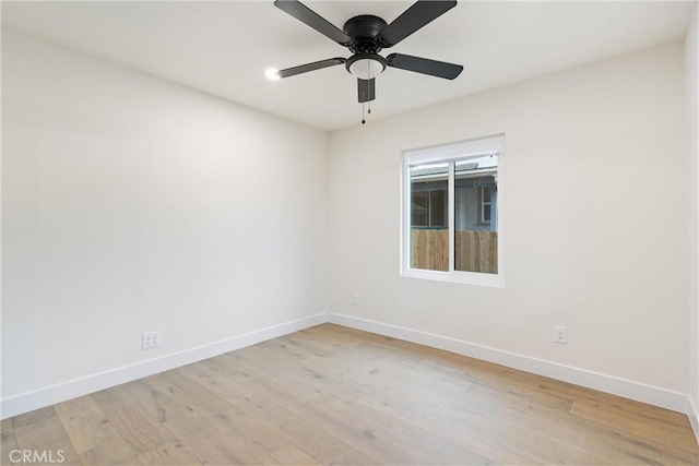 empty room featuring baseboards, light wood finished floors, and a ceiling fan