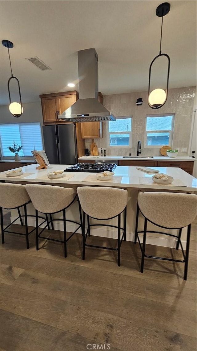 6123 Tipton Way, Los Angeles, CA 90042 - kitchen with island exhaust hood, freestanding refrigerator, a sink, wood finished floors, and a breakfast bar area