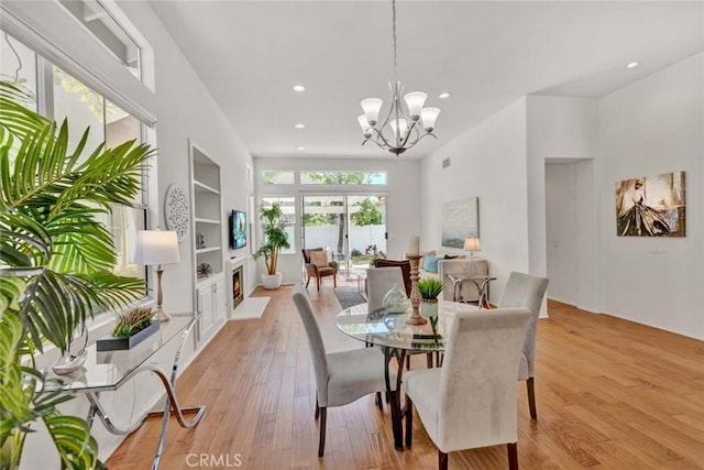 2516 Lewis Dr, Tustin, CA 92782 - dining area with recessed lighting, light wood finished floors, a chandelier, built in features, and a lit fireplace