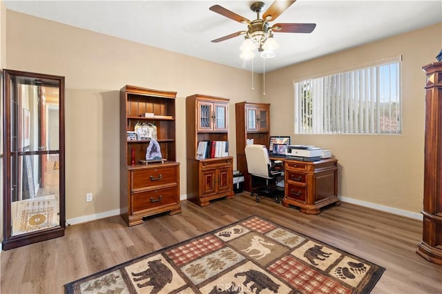 office space featuring baseboards, a ceiling fan, and wood finished floors