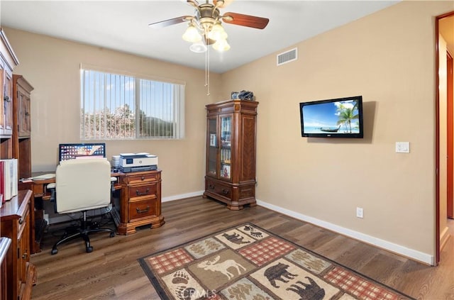 office space with baseboards, visible vents, ceiling fan, and wood finished floors