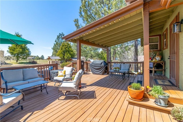 wooden deck with an outdoor hangout area and a grill