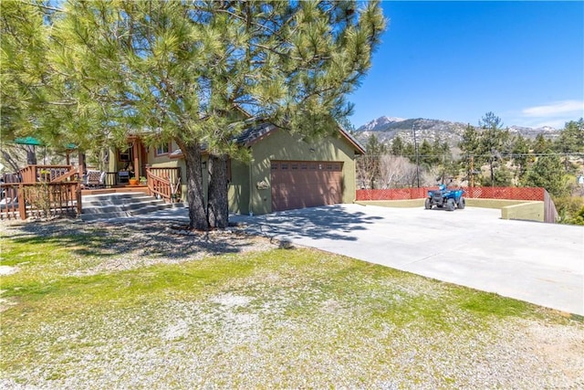 view of home's exterior with a garage, a mountain view, and driveway