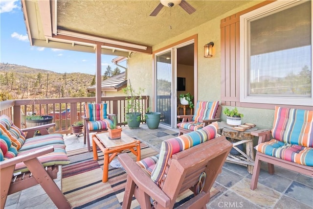 exterior space featuring a ceiling fan and a mountain view