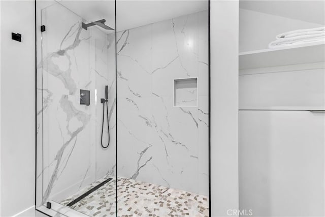bathroom featuring a marble finish shower