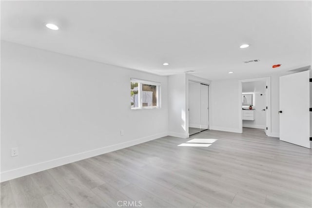 unfurnished living room with light wood-type flooring, visible vents, baseboards, and recessed lighting